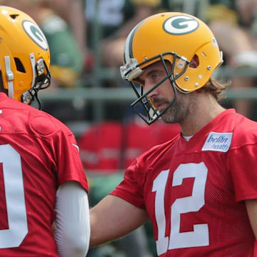 Green Bay Packers quarterback Aaron Rodgers (12) talks with quarterback Jordan Love.