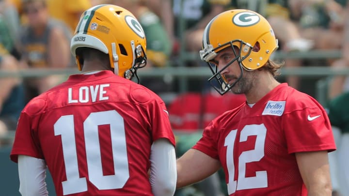 Green Bay Packers quarterback Aaron Rodgers (12) talks with quarterback Jordan Love. Green Bay Packers quarterback Aaron Rodgers (12) talks with quarterback Jordan Love.