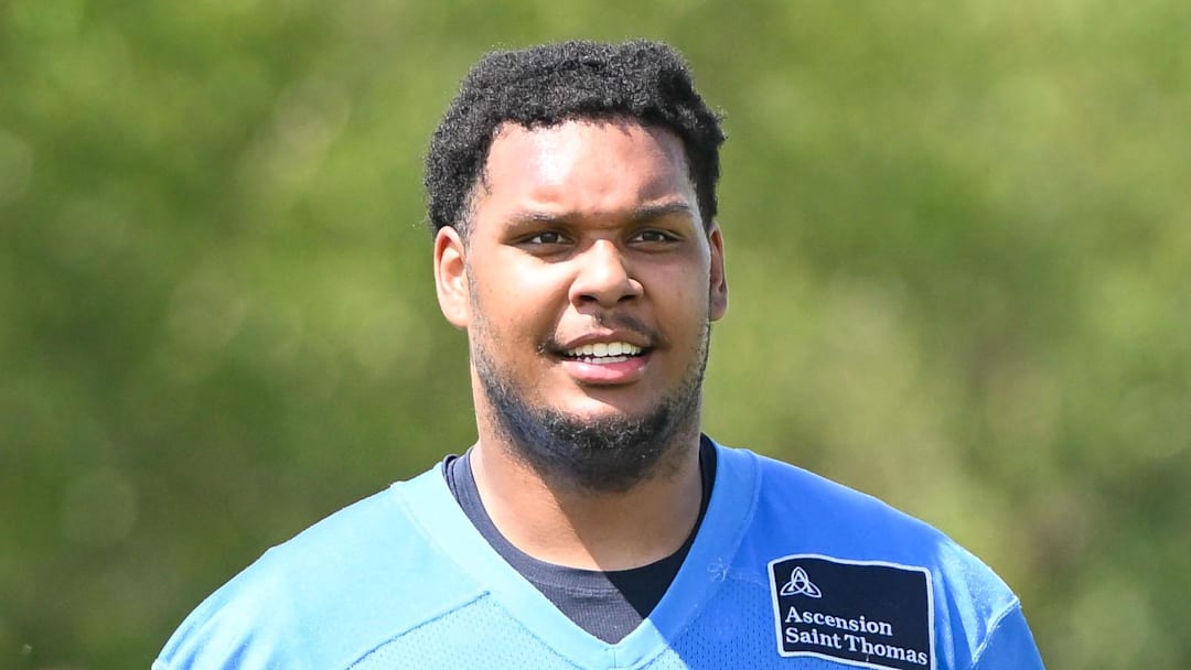 Tennessee Titans tackle Brandon Crenshaw-Dickson is made to carry several helmets during training camp.