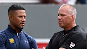 Sep 9, 2023; Raleigh, North Carolina, USA;  Notre Dame Fighting Irish head coach Marcus Freeman (left) and North Carolina State Wolfpack head coach Dave Doeren chat prior to a game at Carter-Finley Stadium. Mandatory Credit: Rob Kinnan-Imagn Images