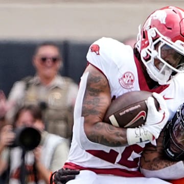 Oklahoma State's Nick Martin (4) tackles Arkansas Razorbacks running back Ja'Quinden Jackson (22) at Boone Pickens Stadium in Stillwater, Okla.