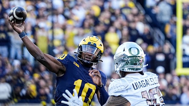 Michigan quarterback Alex Orji (10) makes a pass against Oregon defensive end Matayo Uiagalelei (10)