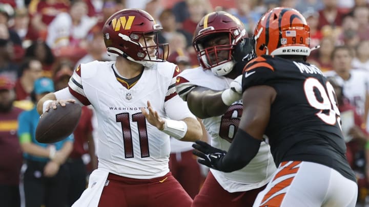 Aug 26, 2023; Landover, Maryland, USA; Washington Commanders quarterback Jake Fromm (11) passes the ball as Cincinnati Bengals defensive end Myles Murphy (99) chases during the second quarter at FedExField. Mandatory Credit: Geoff Burke-USA TODAY Sports