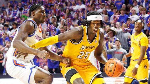 Missouri Tigers forward Mark Mitchell (25) drives against Florida Gators center Rueben Chinyelu at the Stephen C. O'Connell C