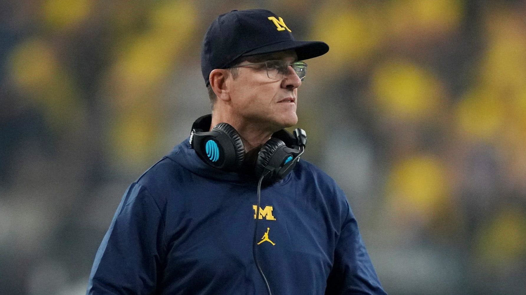 Ex-Michigan Wolverines head coach Jim Harbaugh on the sideline during a college football game in the Big Ten.