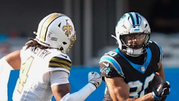 Carolina Panthers running back Chuba Hubbard rushes as New Orleans Saints cornerback Kool-Aid McKinstry defends.