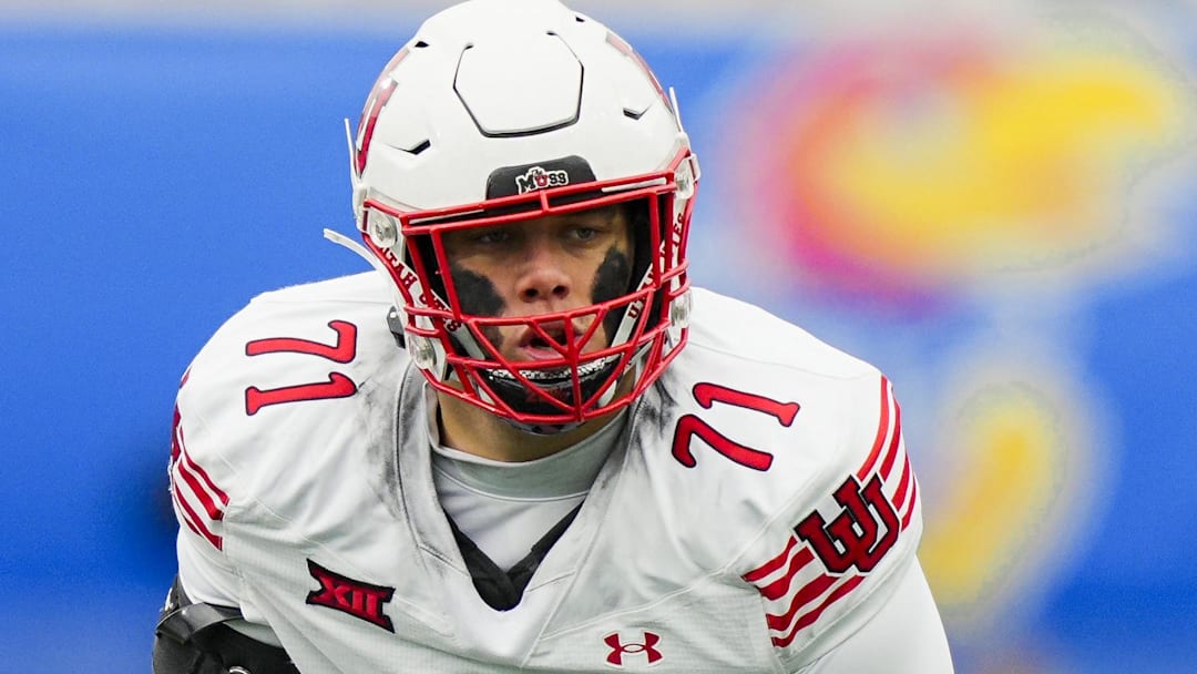 Nov 28, 2025; Lawrence, Kansas, USA; Utah Utes offensive lineman Caleb Lomu (71) gets ready before the snap during the second half against the Kansas Jayhawks at David Booth Kansas Memorial Stadium. Mandatory Credit: Jay Biggerstaff-Imagn Images