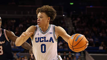 Nov 7, 2025; Los Angeles, California, USA;  UCLA Bruins guard Trent Perry (0) drives to the basket against Pepperdine Waves forward Javon Cooley (23) during the second half at Pauley Pavilion presented by Wescom Financial. Mandatory Credit: Kiyoshi Mio-Imagn Images