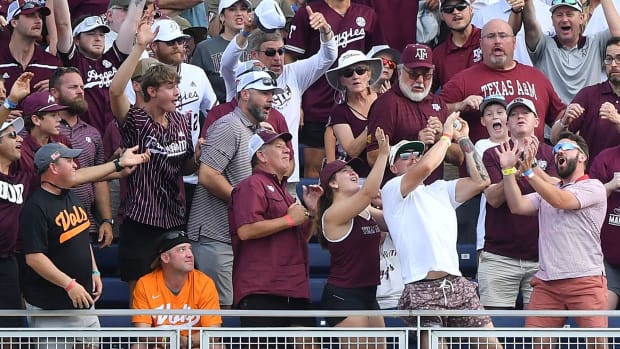 A home run by Texas A&M's Gavin Grahovac (9) is caught by fans during a NCAA College World Series game between Tennessee and Texas A&M at Charles Schwab Field in Omaha, Neb., on Saturday, June 22, 2024.