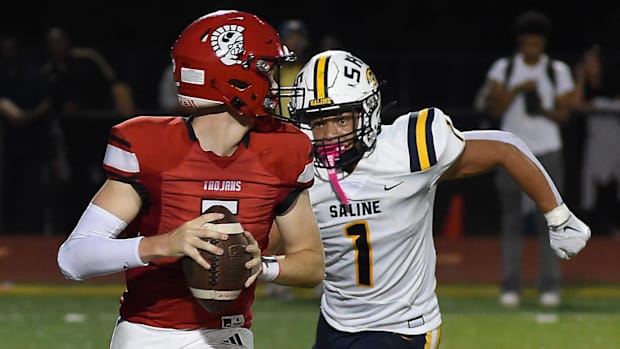 Quarterback Collin Steele of Monroe is sacked by Isaiah Harris of Saline Friday, Sept. 20, 2024.