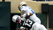 Oct 11, 2025; East Lansing, Michigan, USA; UCLA Bruins defensive back Scooter Jackson (28) tackles Michigan State wide receiver Chrishon McCray (13) after catching a pass in the fourth quarter at Spartan Stadium. Mandatory Credit: Brendan Mullin-Imagn Images