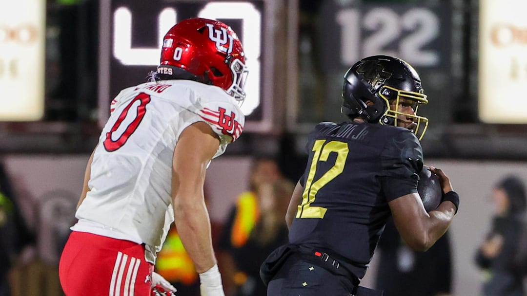 Nov 29, 2024; Orlando, Florida, USA; UCF Knights quarterback EJ Colson (12) carries the ball against Utah Utes defensive end Logan Fano (0) during the second quarter at FBC Mortgage Stadium. Mandatory Credit: Mike Watters-Imagn Images