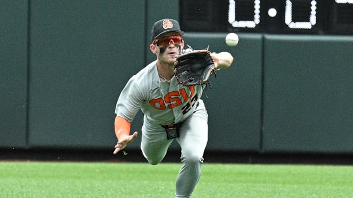 Jun 17, 2025; Omaha, Neb, USA; Oregon State Beavers center fielder Canon Reeder (23) catches a fly ball against the Louisville Cardinals during the second inning at Charles Schwab Field. Mandatory Credit: Steven Branscombe-Imagn Images Jun 17, 2025; Omaha, Neb, USA; Oregon State Beavers center fielder Canon Reeder (23) catches a fly ball against the Louisville Cardinals during the second inning at Charles Schwab Field. Mandatory Credit: Steven Branscombe-Imagn Images