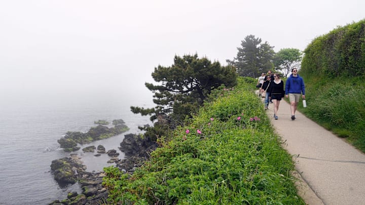 Visitors walk a fog-shrouded portion of Newport's Cliff Walk, one of Rhode Island's premier tourist attractions, on a recent Sunday afternoon.