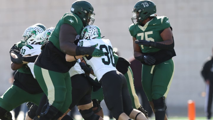 DeSoto's Byron Washington (left) swallows a pass rusher against Southlake Carroll in the Texas (UIL) 6A Division II semis.