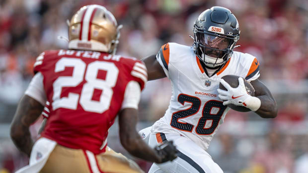 Denver Broncos running back Tyler Badie (28, right) runs the football against San Francisco 49ers cornerback Darrell Luter Jr