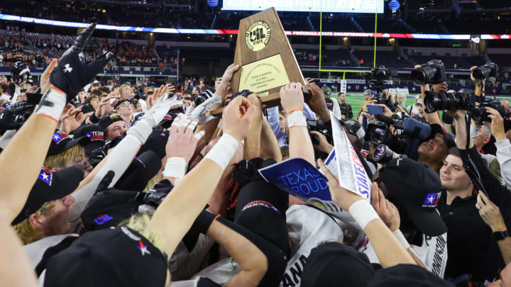 Aledo hoists the UIL (Texas) 5A Division I state championship trophy at AT&T Stadium in Dec. 2023.