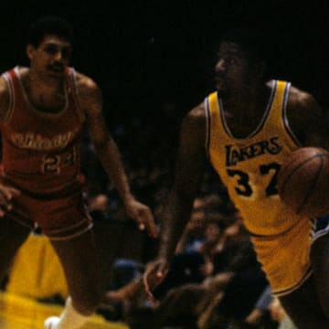 Mar 7, 1980; Inglewood, CA, USA; FILE PHOTO; Los Angeles Lakers shooting guard Magic Johnson (32) in action against Chicago Bulls shooting guard Reggie Theus (24) at The Forum. Mandatory Credit: David Boss-USA TODAY NETWORK