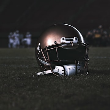 A high school football helmet sits on a field.