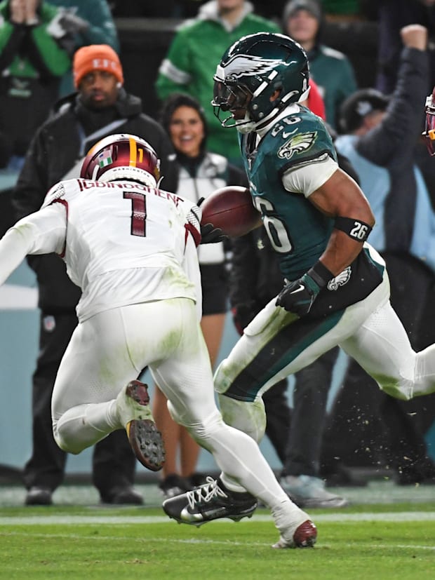 Philadelphia Eagles running back Saquon Barkley (26) and Washington Commanders cornerback Noah Igbinoghene (1)