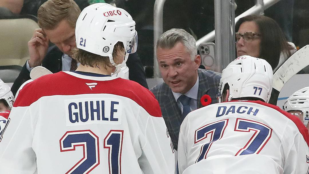 Nov 2, 2024; Pittsburgh, Pennsylvania, USA;  Montreal Canadiens head coach Martin St. Louis (rear) talks to defenseman Kaiden Guhle (21) and center Kirby Dach (77) on the bench against the Pittsburgh Penguins during the third period at PPG Paints Arena. Mandatory Credit: Charles LeClaire-Imagn Images