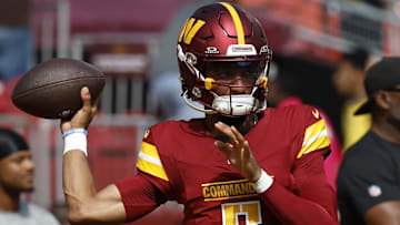 Oct 6, 2024; Landover, Maryland, USA; Washington Commanders quarterback Jayden Daniels (5) passes a ball during warmup prior to the game against the Cleveland Browns at NorthWest Stadium. Mandatory Credit: Geoff Burke-Imagn Images