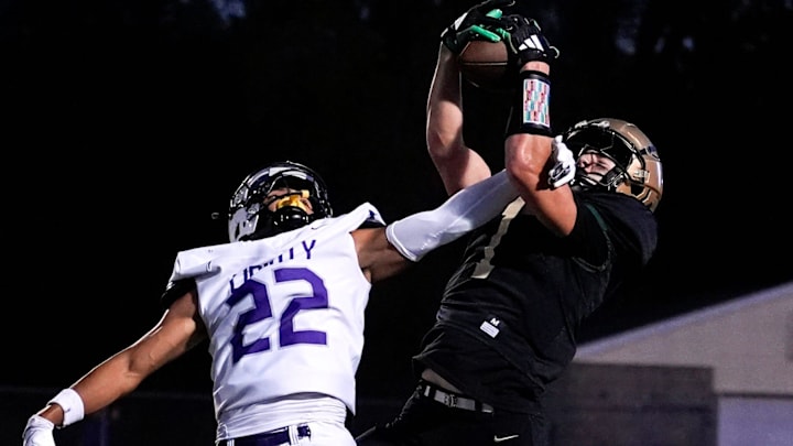 West’s Ethan Headings (1) makes a catch contested by Liberty’s Adrian Clerry (22) during a high school football game Sept. 26, 2025 at Iowa City West in Iowa City, Iowa.