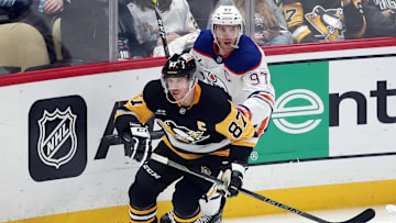 Jan 9, 2025; Pittsburgh, Pennsylvania, USA;  Pittsburgh Penguins center Sidney Crosby (87) and Edmonton Oilers center Connor McDavid (97) chase the puck during the third period at PPG Paints Arena. Mandatory Credit: Charles LeClaire-Imagn Images