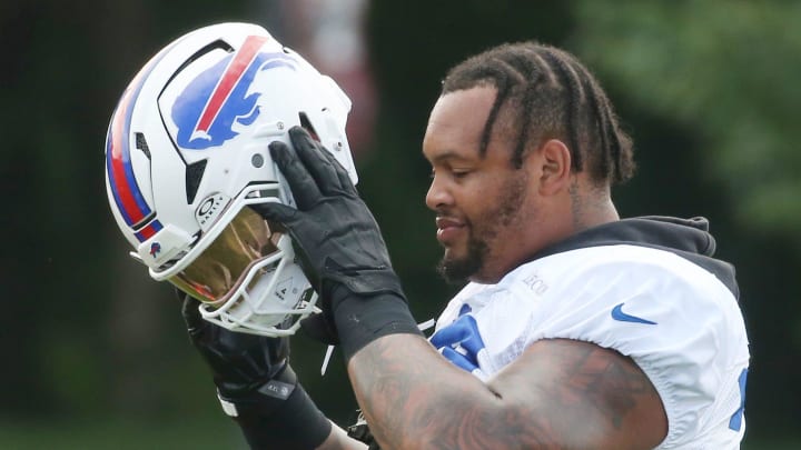 Bills offensive lineman Dion Dawkins pulls on the helmet at the start of day six.