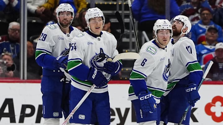 Apr 1, 2026; Denver, Colorado, USA; Members of the Vancouver Canucks celebrate a third period empty net goal by right wing Brock Boeser (6) against the Colorado Avalanche at Ball Arena. 