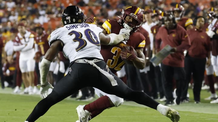 Aug 21, 2023; Landover, Maryland, USA; Washington Commanders running back Jaret Patterson (32) carries the ball past Baltimore Ravens linebacker Trenton Simpson (30) en route to a touchdown during the fourth quarter at FedExField. Mandatory Credit: Geoff Burke-USA TODAY Sports