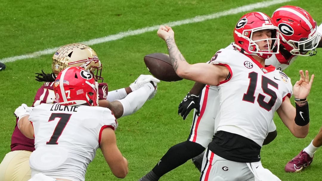 Dec 30, 2023; Miami Gardens, FL, USA; Florida State Seminoles defensive lineman Patrick Payton (11) hits and causes a fumble against Georgia Bulldogs quarterback Carson Beck (15) during the first half in the 2023 Orange Bowl at Hard Rock Stadium. Mandatory Credit: Jasen Vinlove-USA TODAY Sports