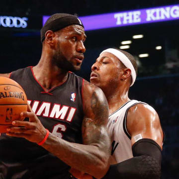 Oct 17, 2013; Brooklyn, NY, USA;  Brooklyn Nets small forward Paul Pierce (34) holds off Miami Heat small forward LeBron James (6) during the first quarter at Barclays Center. Mandatory Credit: Anthony Gruppuso-USA TODAY Sports
