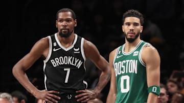 Dec 4, 2022; Brooklyn, New York, USA;  Brooklyn Nets forward Kevin Durant (7) and Boston Celtics forward Jayson Tatum (0) during a time out in the fourth quarter at Barclays Center. Mandatory Credit: Wendell Cruz-Imagn Images
