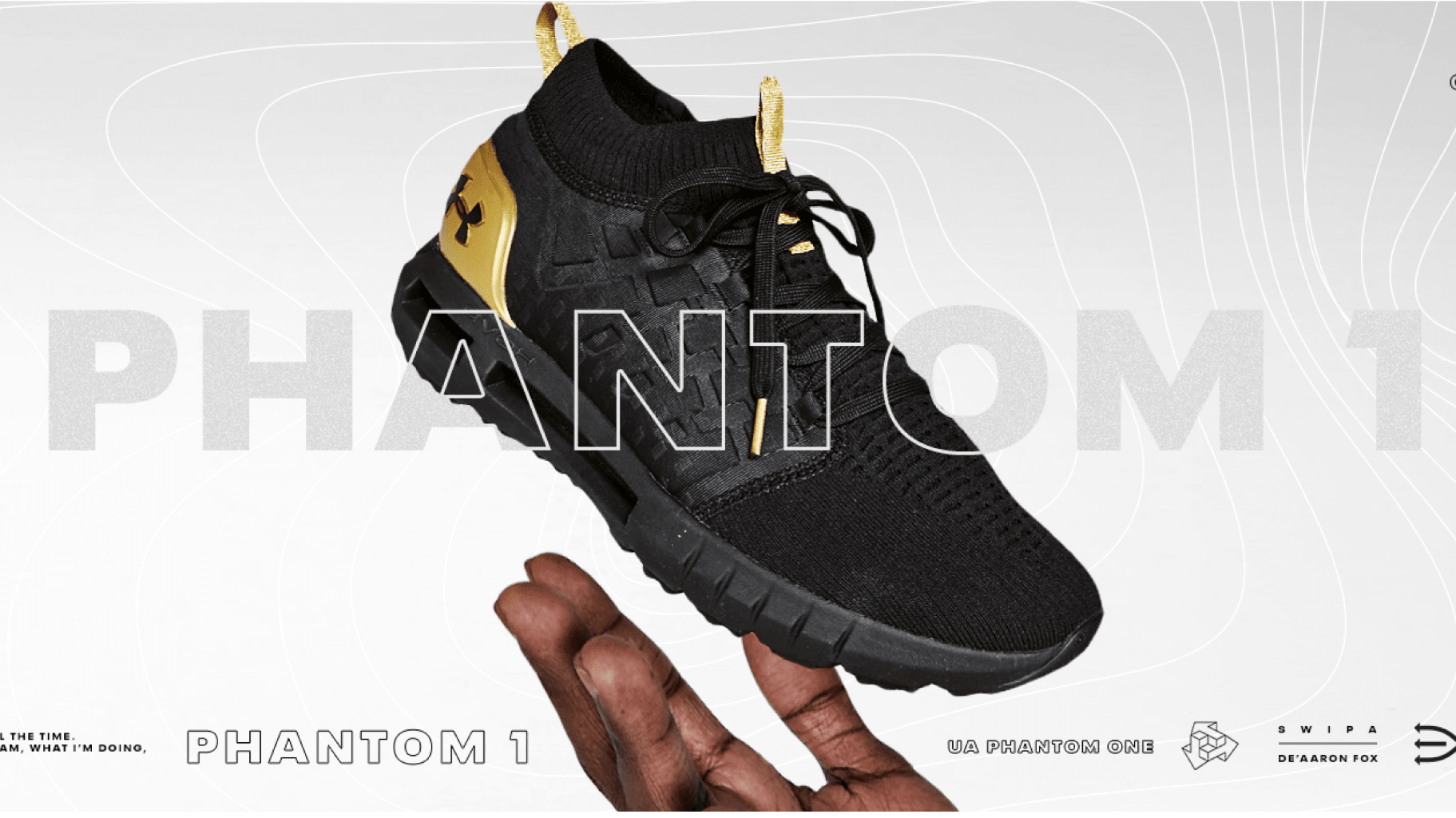 Side view of a black and gold Under Armour sneaker.