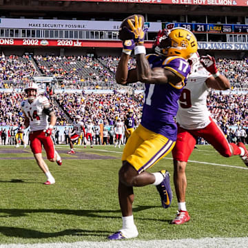 Jan 1, 2024; Tampa, FL, USA; LSU Tigers wide receiver Chris Hilton Jr. (17) catches a pass for a touchdown over Wisconsin Badgers safety Austin Brown (9) during the second half at the Reliaquest Bowl at Raymond James Stadium. Mandatory Credit: Matt Pendleton-Imagn Images