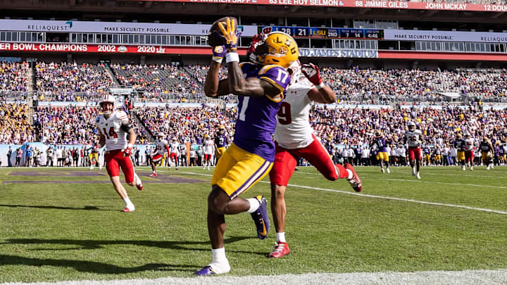 Jan 1, 2024; Tampa, FL, USA; LSU Tigers wide receiver Chris Hilton Jr. (17) catches a pass for a touchdown over Wisconsin Badgers safety Austin Brown (9) during the second half at the Reliaquest Bowl at Raymond James Stadium. Mandatory Credit: Matt Pendleton-Imagn Images