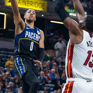 Dec 12, 2022; Indianapolis, Indiana, USA; Indiana Pacers guard Tyrese Haliburton (0) shoots the ball while Miami Heat center Bam Adebayo (13) defends in the first quarter at Gainbridge Fieldhouse. Mandatory Credit: Trevor Ruszkowski-Imagn Images