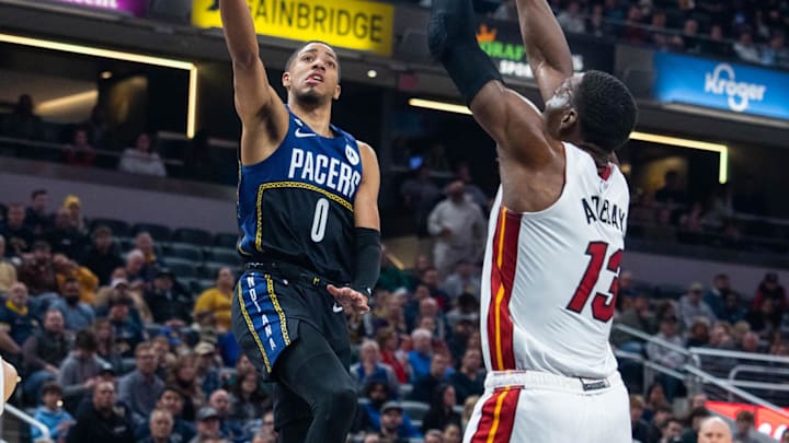 Dec 12, 2022; Indianapolis, Indiana, USA; Indiana Pacers guard Tyrese Haliburton (0) shoots the ball while Miami Heat center Bam Adebayo (13) defends in the first quarter at Gainbridge Fieldhouse. Mandatory Credit: Trevor Ruszkowski-Imagn Images