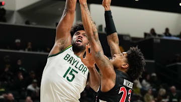 Jan 7, 2025; Waco, Texas, USA;  Baylor Bears forward Norchad Omier (15) scores a basket as Cincinnati Bearcats forward Dillon Mitchell (23) defends during the first half at Paul and Alejandra Foster Pavilion. Mandatory Credit: Chris Jones-Imagn Images