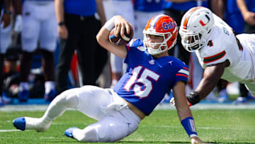 Florida Gators quarterback Graham Mertz (15) slides during a play while being pursued by Miami Hurricanes defensive lineman Rueben Bain Jr. (4) uring the season opener at Ben Hill Griffin Stadium in Gainesville, FL on Saturday, August 31, 2024 against the University of Miami Hurricanes in the first half. [Doug Engle/Gainesville Sun]