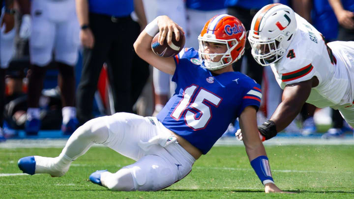 Florida Gators quarterback Graham Mertz (15) slides during a play while being pursued by Miami Hurricanes defensive lineman Rueben Bain Jr. (4) uring the season opener at Ben Hill Griffin Stadium in Gainesville, FL on Saturday, August 31, 2024 against the University of Miami Hurricanes in the first half. [Doug Engle/Gainesville Sun]