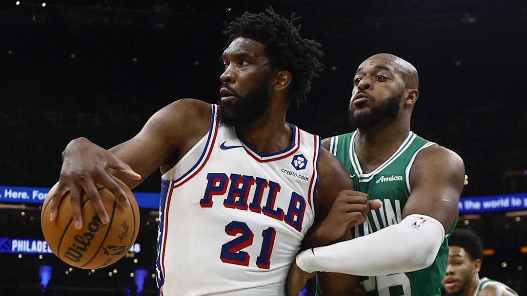Oct 22, 2025; Boston, Massachusetts, USA;Boston Celtics forward Xavier Tillman (26) grabs hold of Philadelphia 76ers center Joel Embiid (21) during the second quarter at TD Garden. Mandatory Credit: Winslow Townson-Imagn Images