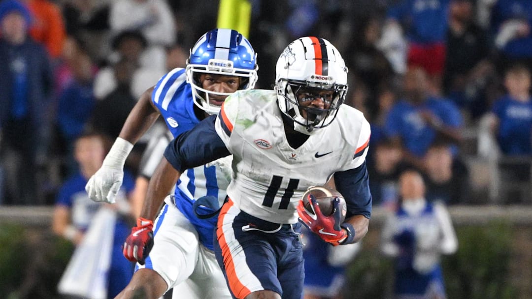 Nov 15, 2025; Durham, North Carolina, USA;  Virginia Cavaliers wide receiver Trell Harris (11) runs the ball against  Duke Blue Devils defensive end Tyshon Reed (10) during the third quarter at Wallace Wade Stadium. Mandatory Credit: Zachary Taft-Imagn Images