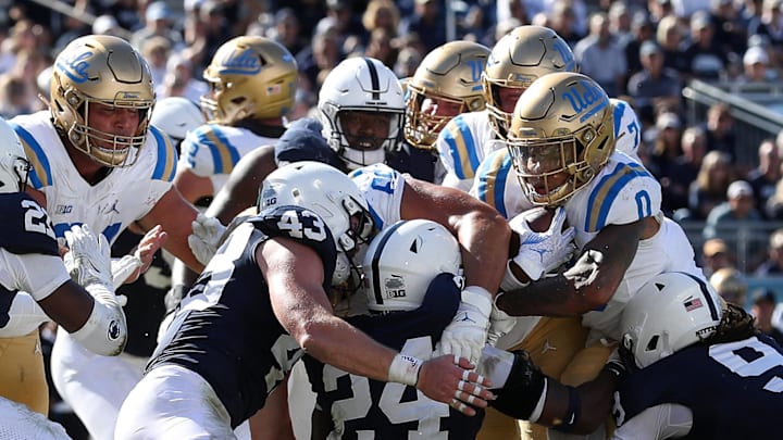 Oct 5, 2024; University Park, Pennsylvania, USA; UCLA Bruins running back Jalen Berger (0) attempts to push forward with the ball against the Penn State Nittany Lions defense during the fourth quarter at Beaver Stadium. Mandatory Credit: Matthew O'Haren-Imagn Images Oct 5, 2024; University Park, Pennsylvania, USA; UCLA Bruins running back Jalen Berger (0) attempts to push forward with the ball against the Penn State Nittany Lions defense during the fourth quarter at Beaver Stadium. Mandatory Credit: Matthew O'Haren-Imagn Images