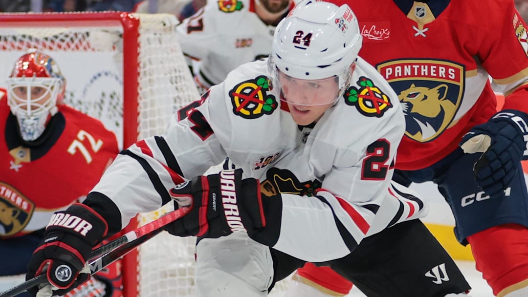 Oct 7, 2025; Sunrise, Florida, USA; Chicago Blackhawks center Sam Lafferty (24) moves the puck against Florida Panthers center Anton Lundell (15) during the second period at Amerant Bank Arena. Mandatory Credit: Sam Navarro-Imagn Images