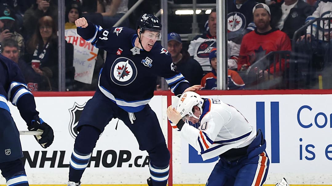 Jan 8, 2026; Winnipeg, Manitoba, CAN; Winnipeg Jets defenseman Logan Stanley (64) fights with Edmonton Oilers center Trent Frederic (10) in the second period at Canada Life Centre. Mandatory Credit: James Carey Lauder-Imagn Images
