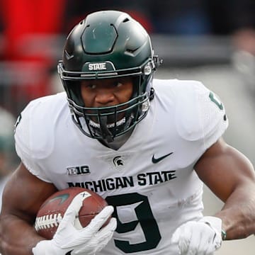 Michigan State running back Kenneth Walker III runs past Ohio State Buckeyes defensive tackle Jerron Cage during the first quarter at Ohio Stadium in Columbus, Ohio on Nov. 20, 2021.

Syndication The Providence Journal