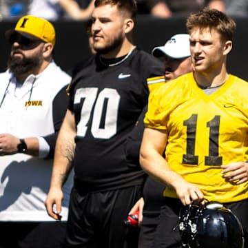 Apr 26, 2025; Iowa City, IA, USA; Iowa offensive lineman Beau Stephens (70) quarterback Mark Gronowski (11) and offensive lineman Logan Jones (65) stand with Iowa head coach Kirk Ferentz during a spring NCAA football open practice at Kinnick Stadium. Mandatory Credit: Joseph Cress/For the Register
