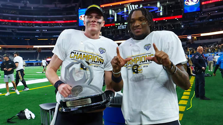 Brady Cook & Luther Burden lll pose with the Cotton Bowl trophy last December.